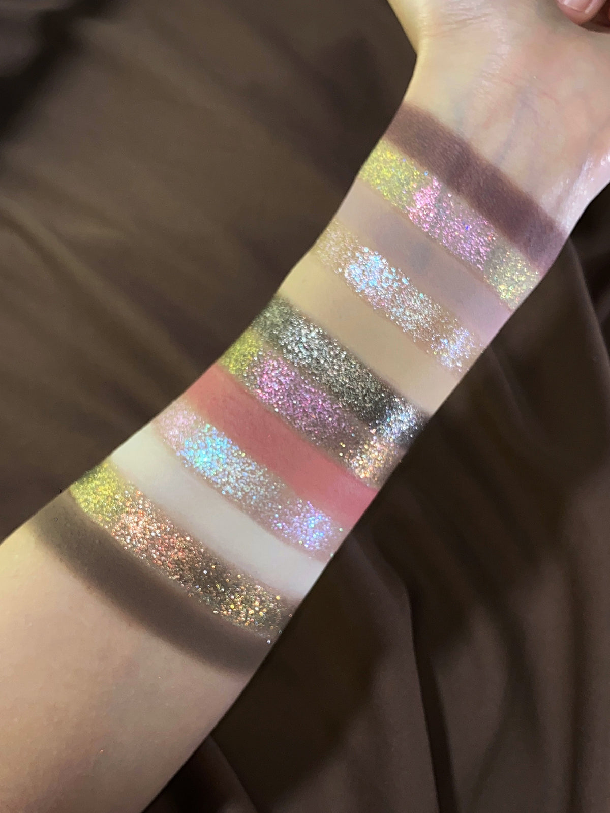 Pâtisserie arm swatches in warmer light over brown satin, the sparkle shades catching green, pink and icy blue