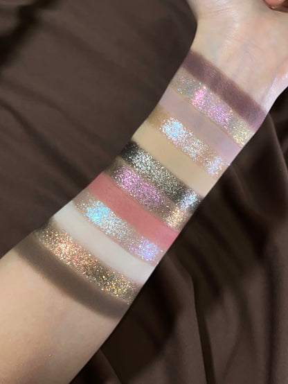 Pâtisserie arm swatches over brown satin, mattes from plum to cream alternating with pink, icy and gold sparkle shades