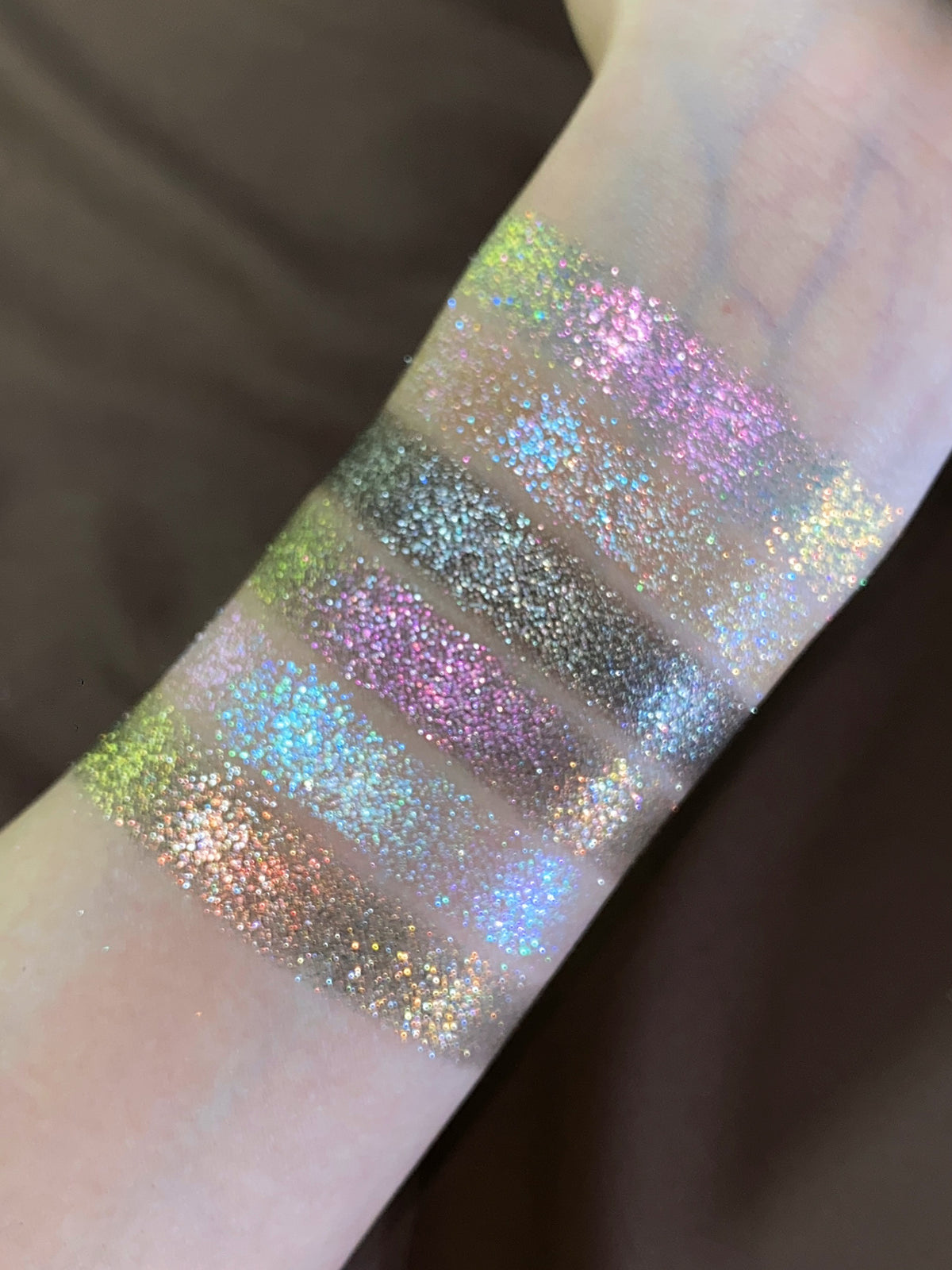 Close-up of the Pâtisserie sparkle shades swatched together, shifting between green, pink, blue and gold