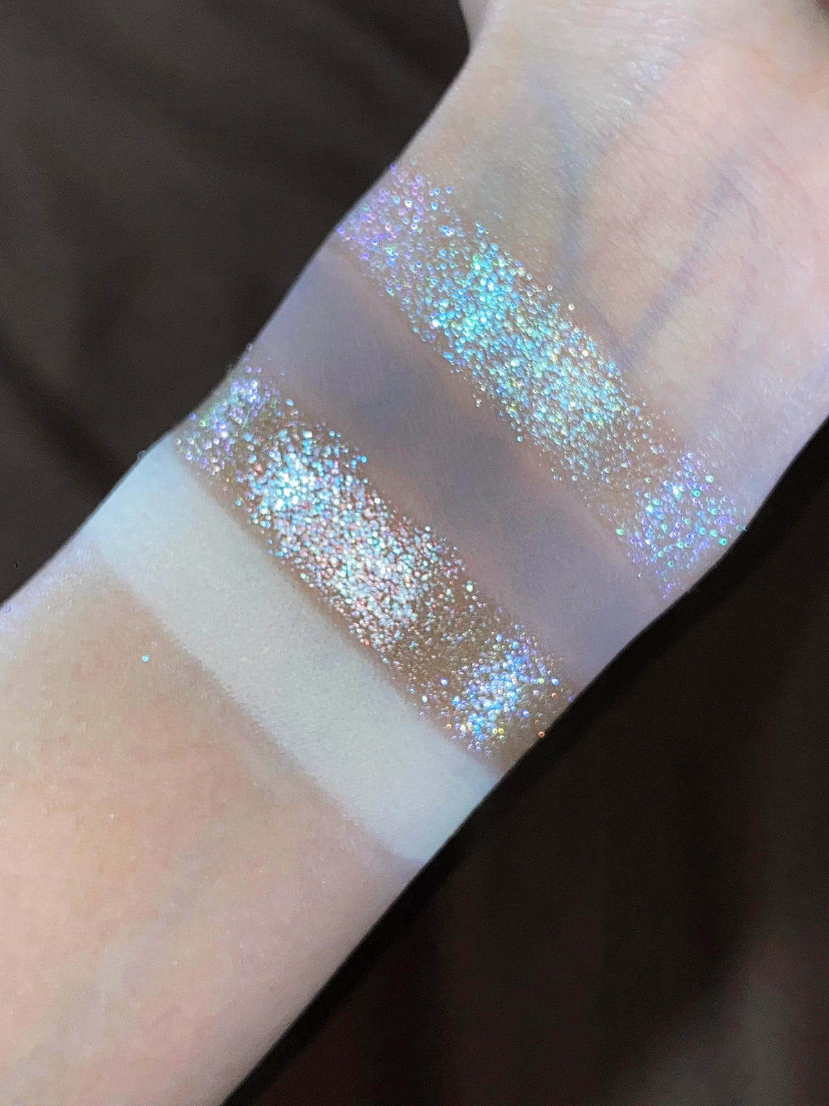 Close-up swatches: cream and beige mattes with icy blue and pink sparkle shades