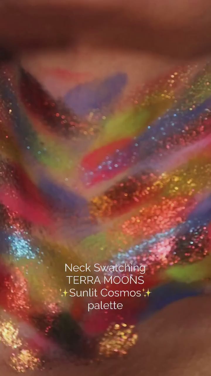 Neck swatch video of the Sunlit Cosmos palette, the full range brushed on in stripes of pink, yellow, blue, orange and red with sparkle shades layered over them