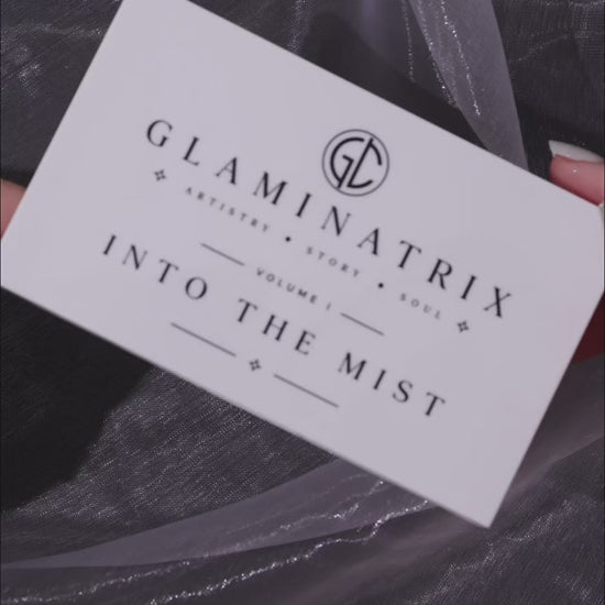 Video of Into the Mist finger swatches on a light and a deep skin tone over dark marble, with the lid card beside each arm