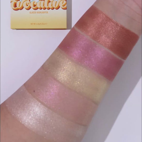 Video of all five highlighter shades swatched in a row on a forearm beside the yellow Evocative box