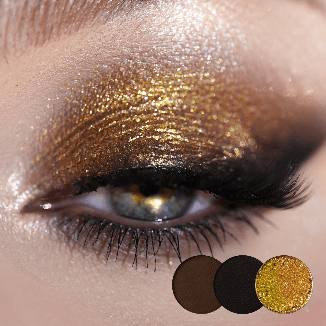 Close-up of an eye with gold shimmer across the lid and a smoky brown and black edge, brown, black and gold shade dots below.
