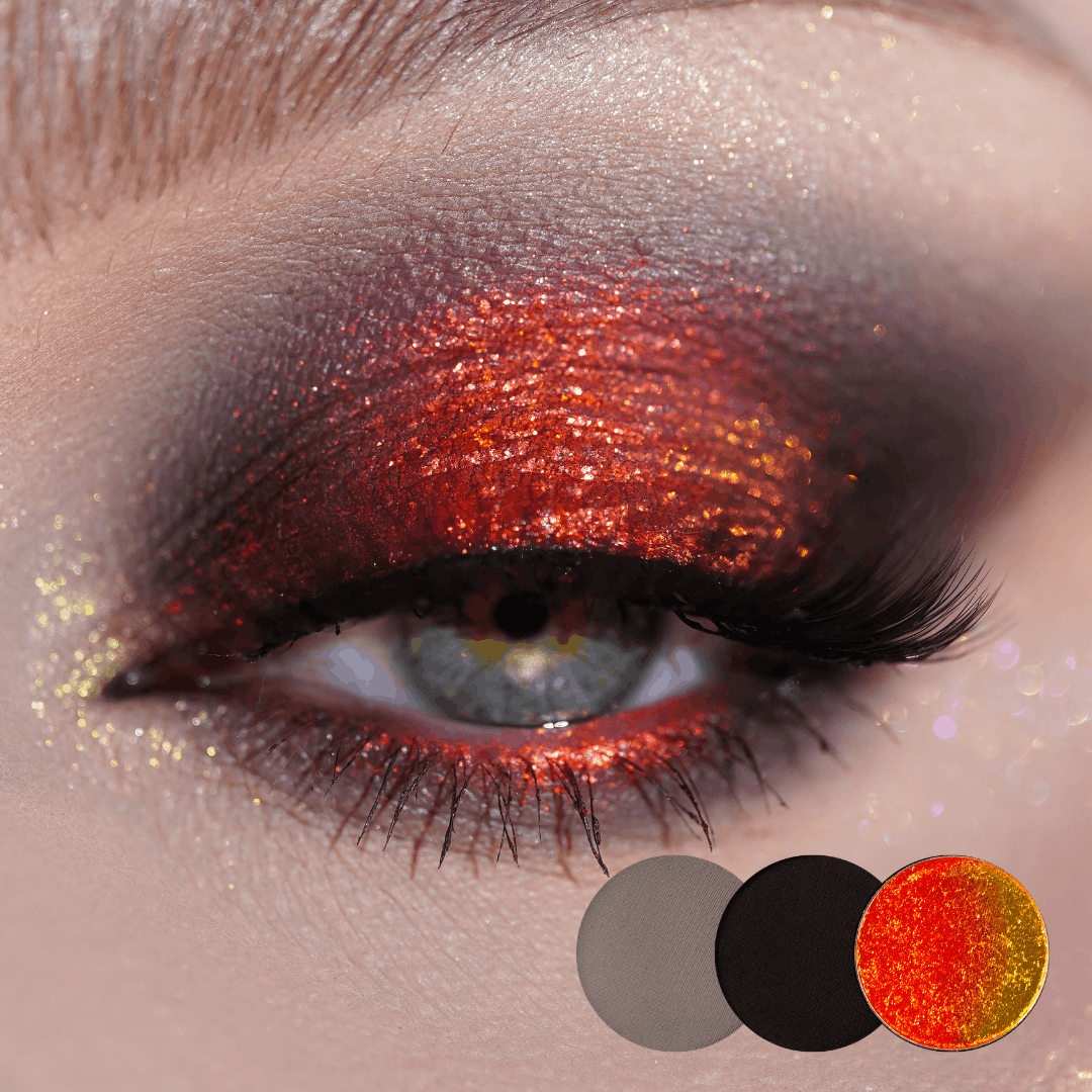 Close-up of a blue-grey eye with orange-red shimmer on the lid and a smoky black edge, grey, black and orange shade dots below.