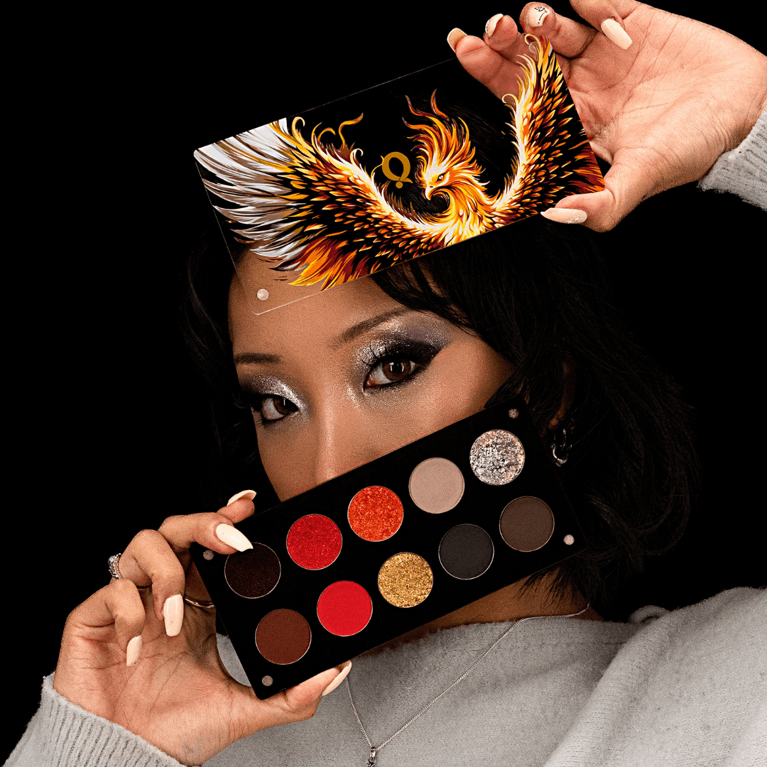 Model holding the phoenix lid above the head and the open palette across the lower face, wearing a smoky silver eye look.