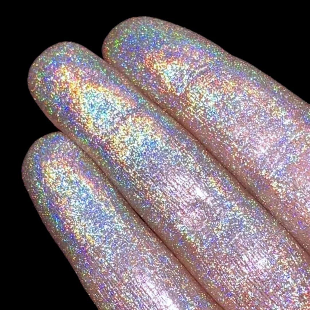 Question Beauty multichrome loose pigment swatched on four fingers - holochrome finish with rainbow light scatter across light skin, black background