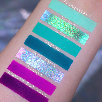 Seven cool shades swatched on light skin: Tranquility, Lithia, Oasis, Lagoon, Pool Party, Zinnia, and Summer Solstice