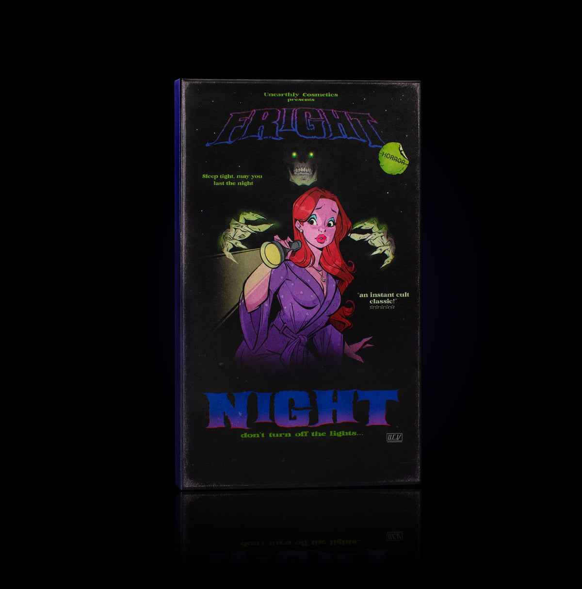 Fright Night eyeshadow palette by Unearthly Cosmetics closed, VHS-style box with a red-haired woman holding a torch, clawed hands and a green-eyed skull